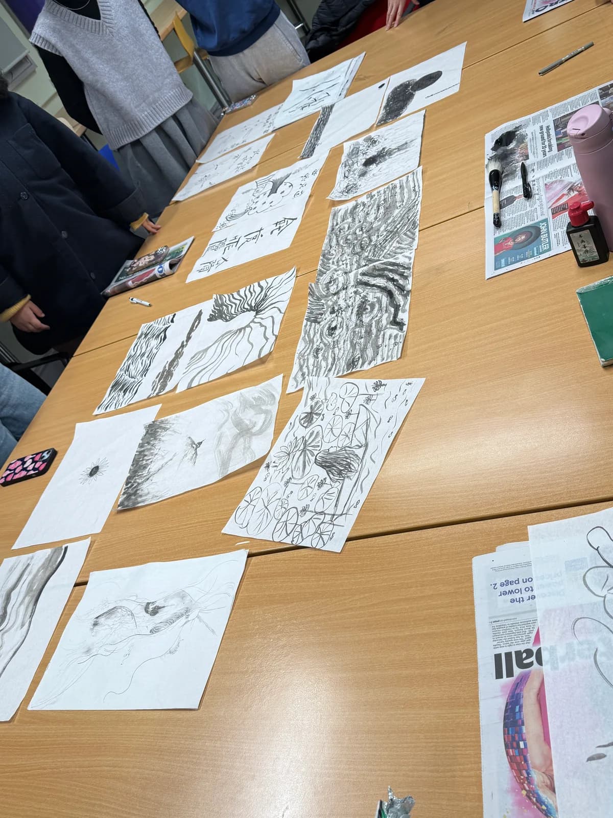 Ink drawings and brushes spread across the table.